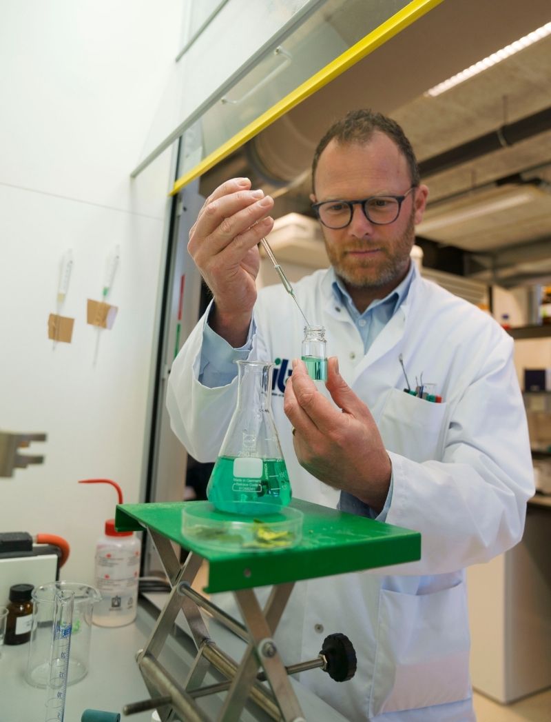 Onderzoeker met plantenstoffen in laboratorium plantenextractenbibliotheek